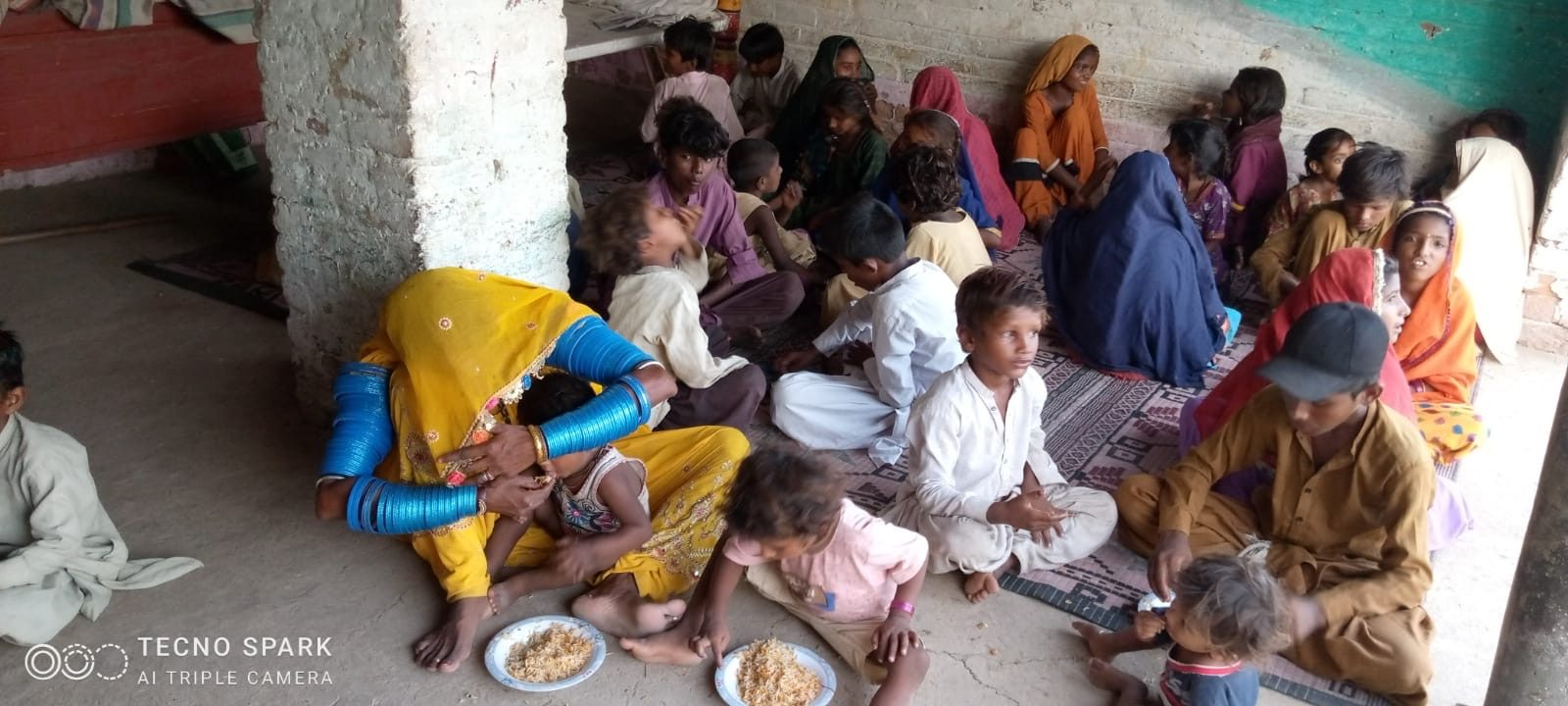 Families gathered for a meal distribution in Pakistan
